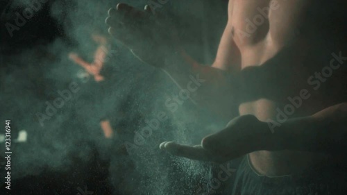 Muscular man use magnesia dust for next training