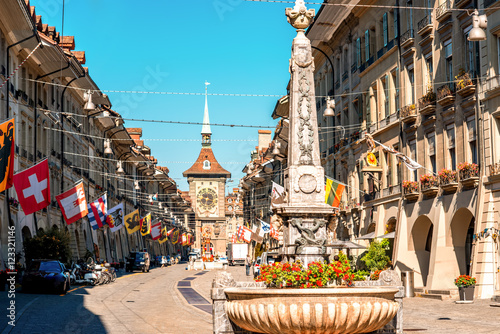Street view on Kramgasse with fountain and clock tower in the old town of Bern city. It is a popular shopping street and medieval city centre of Bern, Switzerland photo