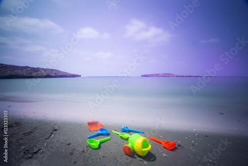children's beach toys on the shore, long exposure