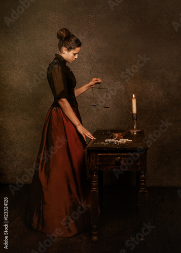 Portrait of a teenage girl holding antique weights