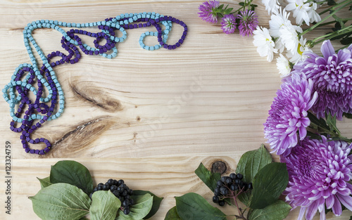 beautiful flowers and jewelry on a wooden background