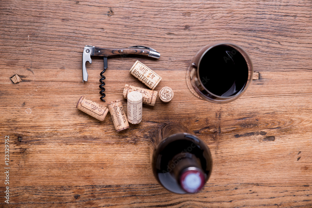 wine concept flat lay still life with bottle and glass of wine, corks and corkscrew