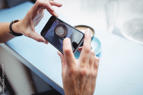 Photography Woman taking photo of a coffee from mobile phone