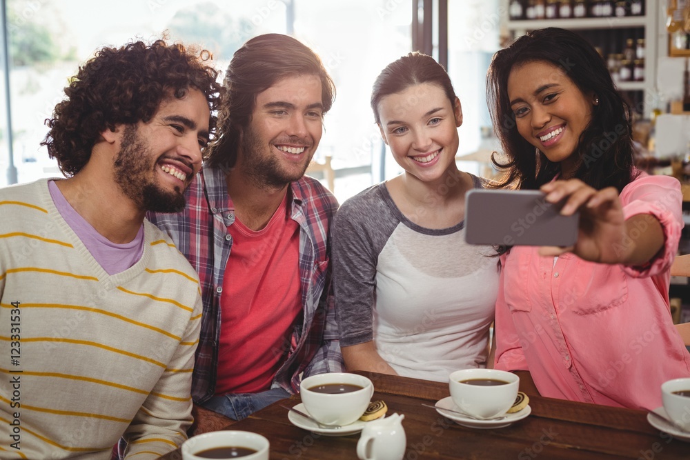Group of friends taking a selfie while having cup of coffee Group of friends taking a selfie while having cup of coffee