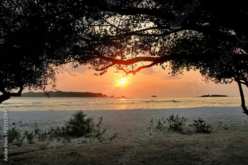 The sun go down behind the horizon of the ocean in the Maldives