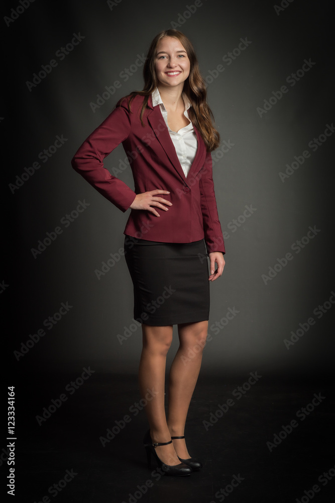 Fototapeta premium Junge Studentin in Ganzkörperansicht - Junge Frau im Bussinessoutfit lächelt 