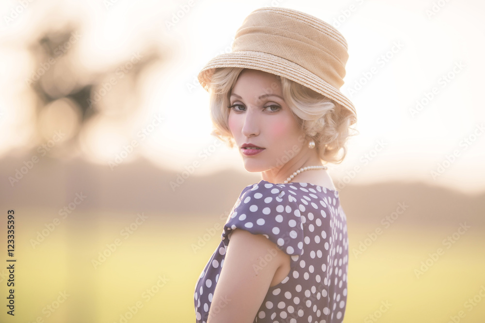 Fototapeta premium Seductive looking woman wearing vintage 1930s fashion. Standing