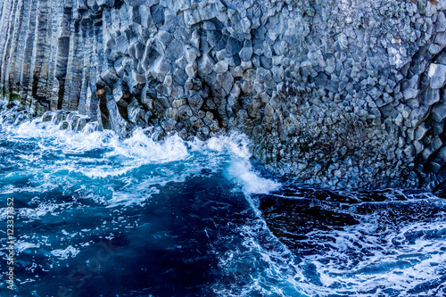 The blue ocean water and the volcanic rock formations at the coast of West Iceland