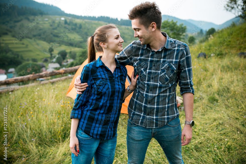 Guy and girl lovers tourists relax and admire beautiful mountain scenery Guy and girl lovers tourists relax and admire beautiful mountain scenery