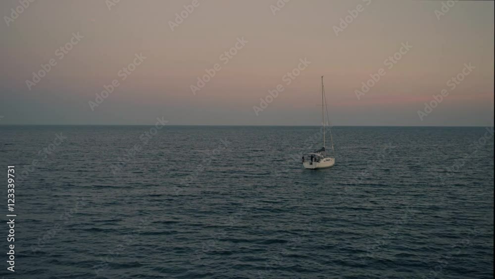 Lonely sail boat waves in ocean in twilight, peaceful view with sunset light Lonely sail boat waves in ocean in twilight, peaceful view with sunset light