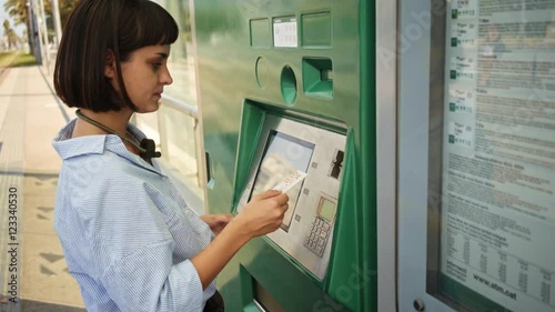 Wallpaper Mural Pretty brunette girl uses vending machine to buy public transport ticket with her credit card Torontodigital.ca