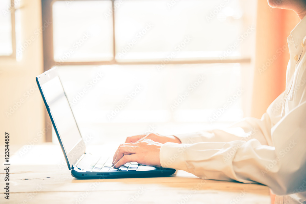 Business women hands working with laptop on wooden desk, lighing effect Business women hands working with laptop on wooden desk, lighing effect