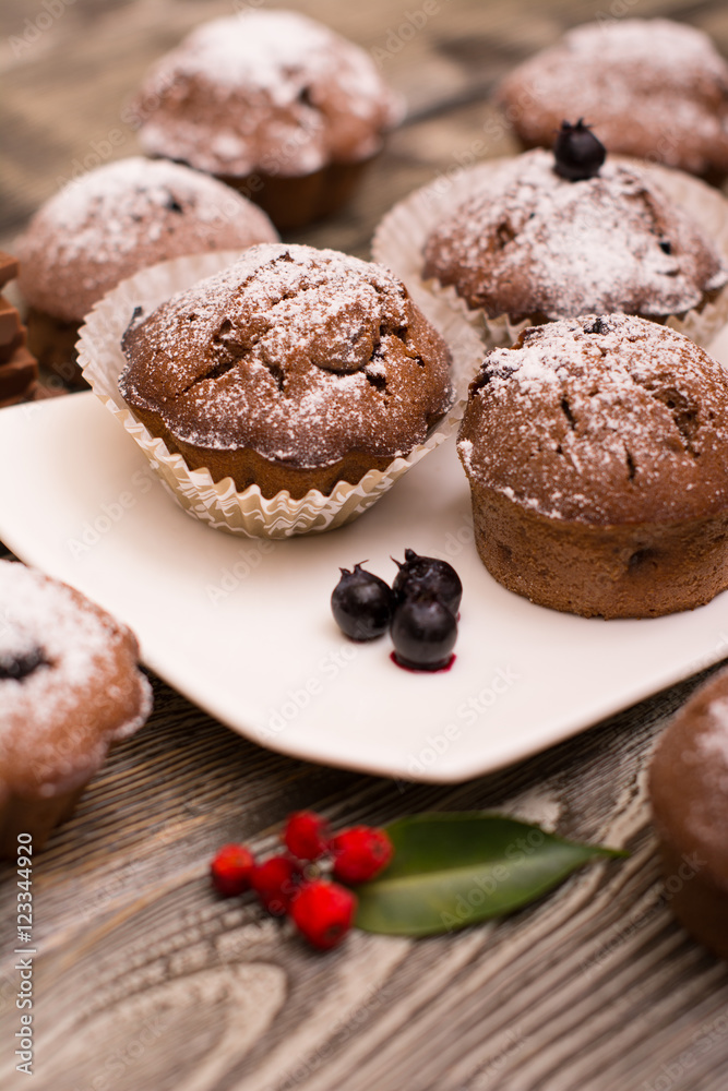 cupcake with berries on a white plate, wooden background cupcake with berries on a white plate, wooden background