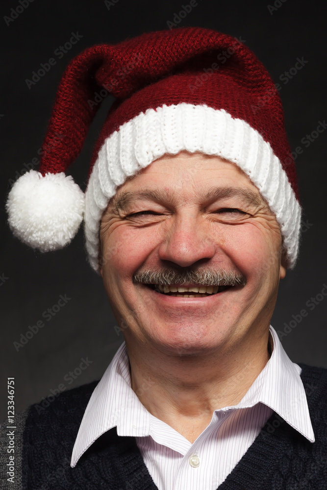 Happy man in a New Year's cap laughing. Preparing for the New Year and Christmas Happy man in a New Year's cap laughing. Preparing for the New Year and Christmas