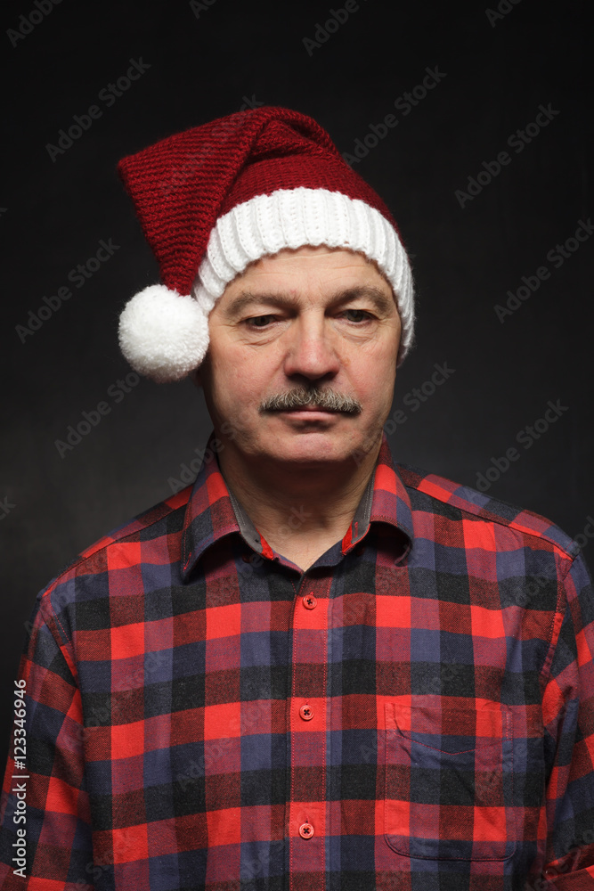 Man in New Year's cap looks sad. Bad mood before Christmas Man in New Year's cap looks sad. Bad mood before Christmas