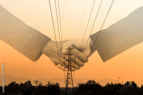 Shaking hand with agreement with Electrical transmissiontower photo