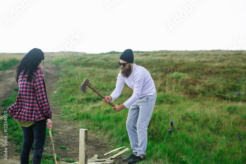 Man cuts wood with girlfriend