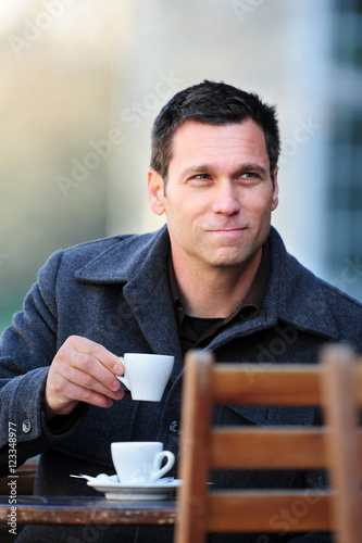 Man drinking espresso at Paris sidewalk cafe
