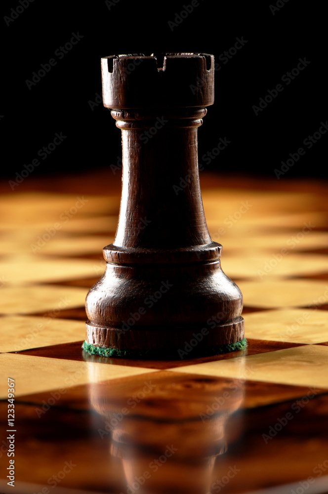 Premium Photo  The golden rook chess piece standing alone on chess board  background rook or the castle the tower symbolize a protectorate of the city