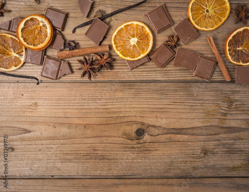 chocolate with cinnamon, orange and vanilla on wooden table