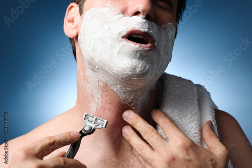 Obraz na plátně Closeup man shaving with razor burn rash bumps pain ingrown hair nicks and cuts