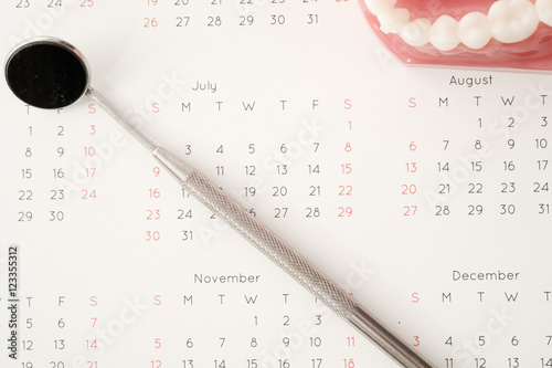 Dentist tool and demonstration teeth model on calendar