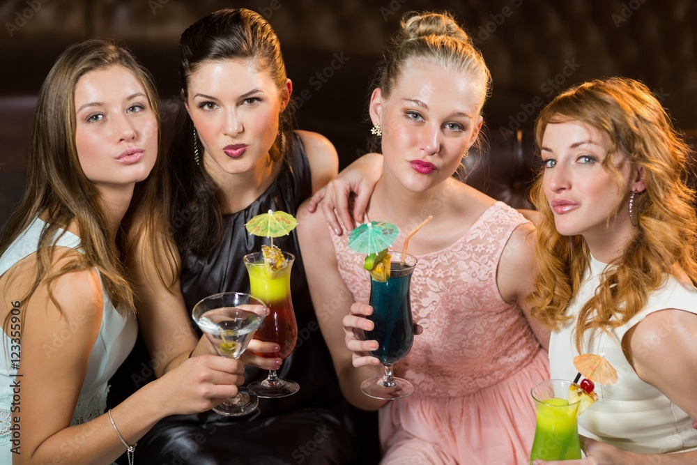 Female friends holding glasses of cocktail in bar