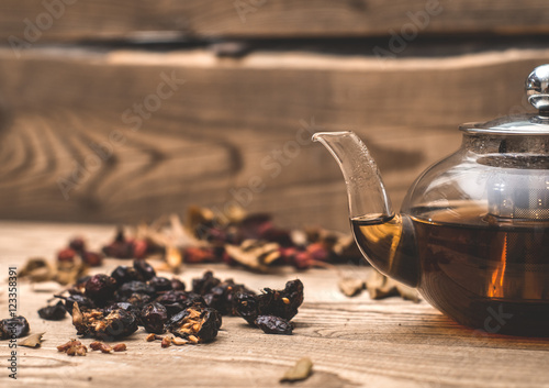 hot herbal tea in a transparent teapot on a wooden table