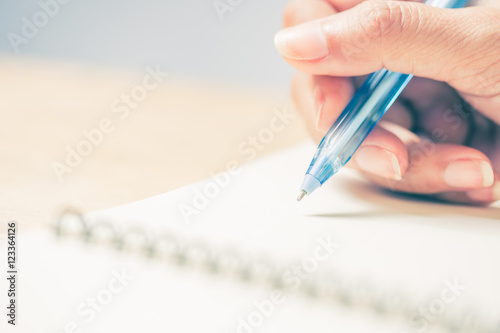 Business women hands working writing notebook on wooden desk, lighing effect