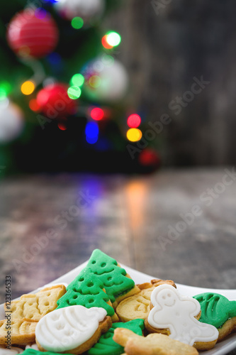 Christmas cookies and Christmas tree on wooden background