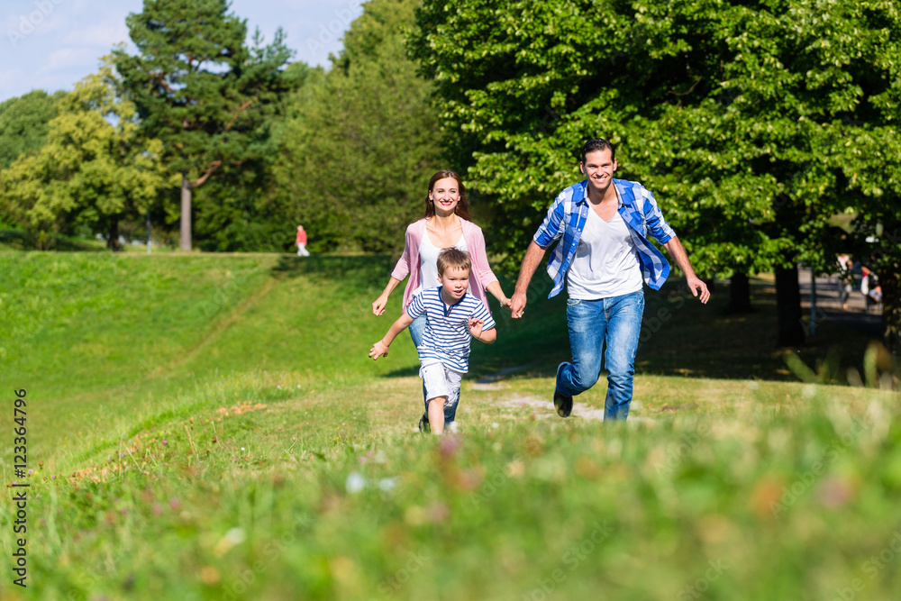 Familie rennt schnell über Gras auf der Wiese Familie rennt schnell über Gras auf der Wiese