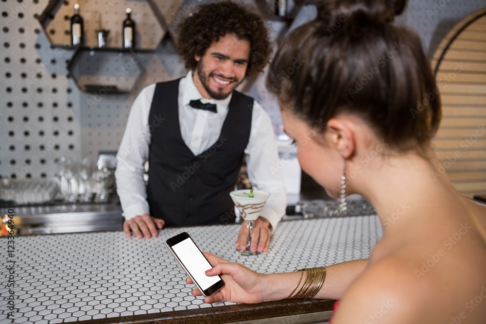 Obraz premium Waiter interacting with beautiful woman while using mobile phone