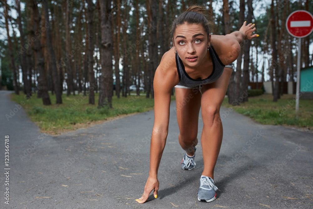 Fototapeta premium Young woman running outdoors in a city park