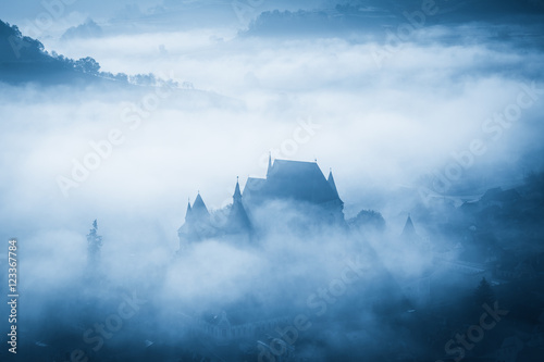 Mysterious misty morning over Biertan village  Transylvania  Romania. Blue colors. spooky  Halloween concept