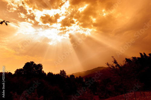 Fotografie The sun's rays make their way through the dark cloud.