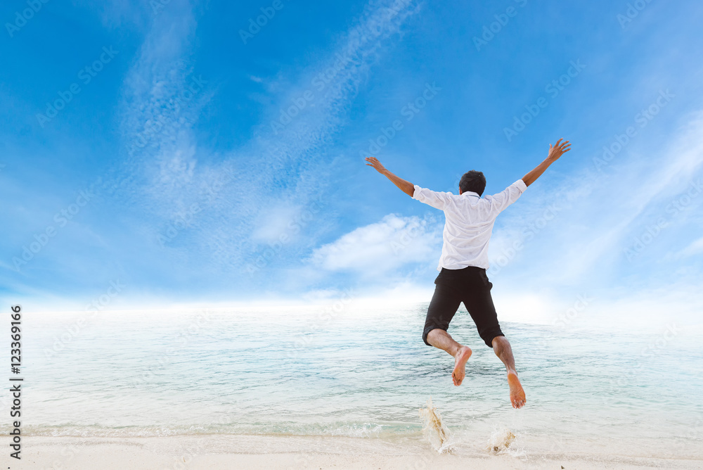 Happiness of businessman jumping relax on beautiful sea beach at