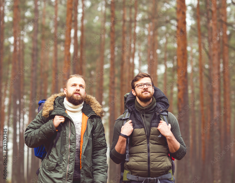 Man with a backpack and beard and his friend in forest