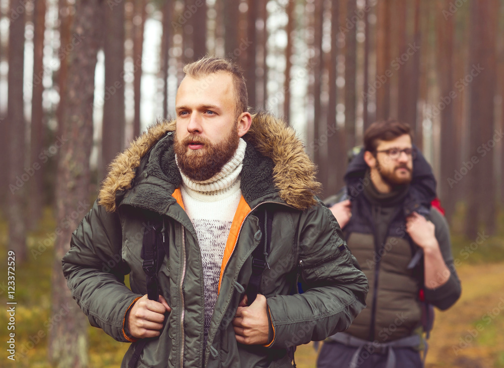 Man with a backpack and beard and his friend in forest Man with a backpack and beard and his friend in forest