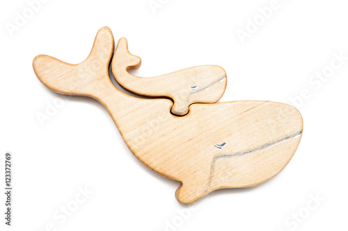 Wooden puzzle in the form of a whale and little whale isolated on white.