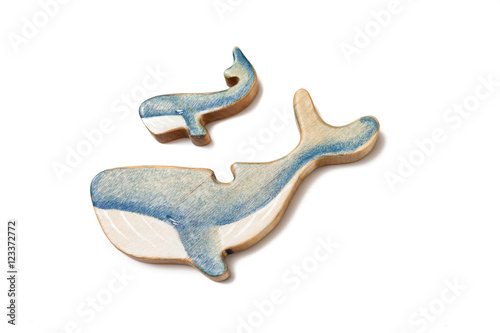 Wooden puzzle in the form of a whale and little whale isolated on white.