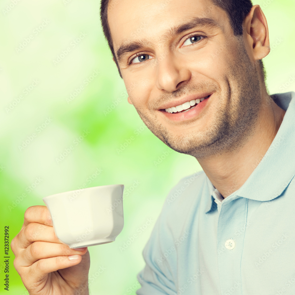 Happy smiling man drinking coffee, outdoors Happy smiling man drinking coffee, outdoors