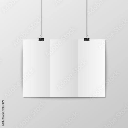 Sheet of folded paper hangs on the clamps.