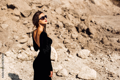 Pretty woman in long black dress walking outdoor