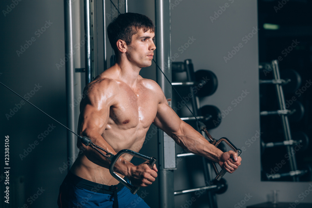 handsome bodybuilder works out pushing up excercise in gym