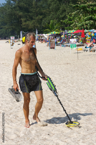 PHUKET, THAILAND - MARCH 25, 2016:Treasure hunter with Metal detector on the beach