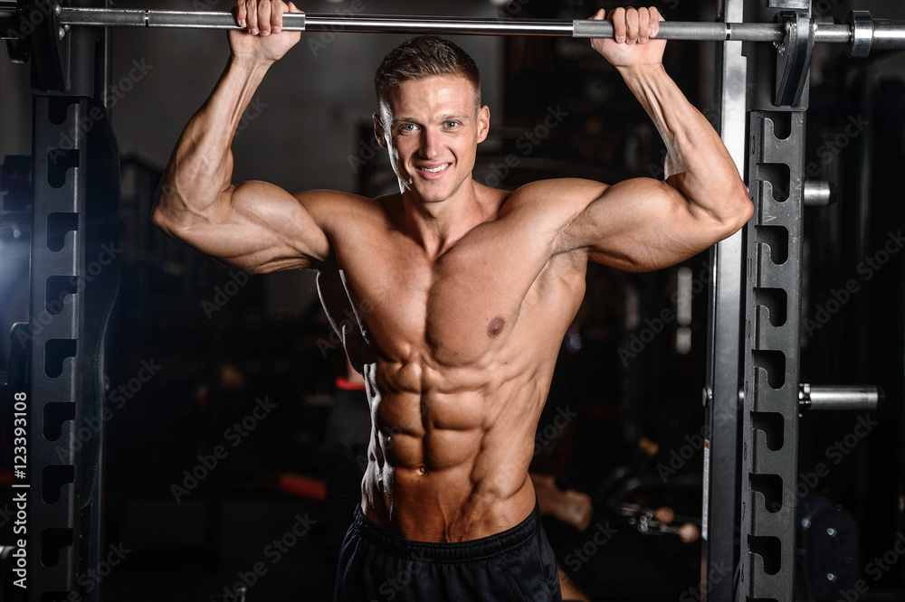 Strong athletic man fitness model showing six pack abs