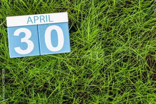 April 30th. Day 30 of month, calendar on football green grass background. Spring time, empty space for text