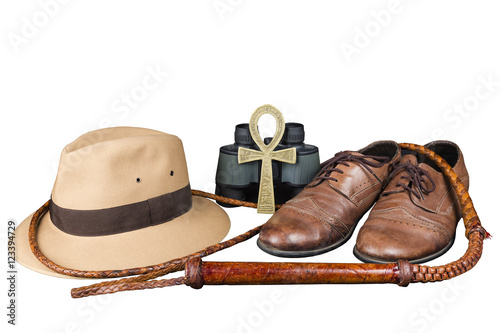 Travel and adventure concept. Vintage brown shoes with fedora hat, bullwhip, binoculars and key of life ankh isolated