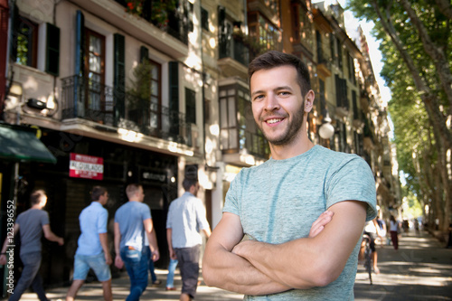 Young happy man smiling at camera in the city