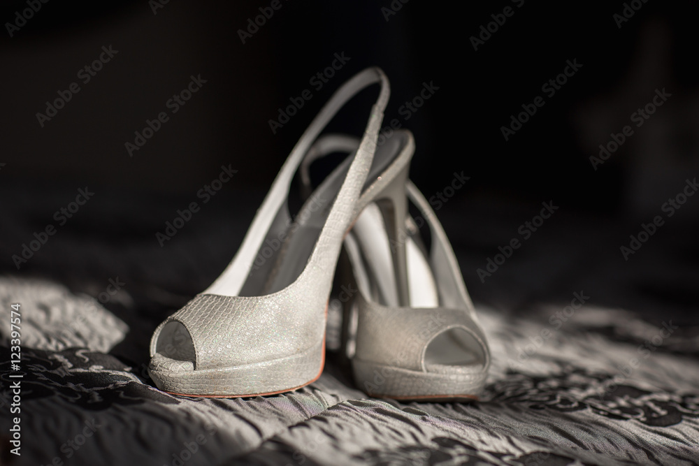 Wedding shoes. Ray of sunshine emphasized the beauty of women weddingl shoes. Silver shoes of beautiful bride. Wedding shoes. Ray of sunshine emphasized the beauty of women weddingl shoes. Silver shoes of beautiful bride.